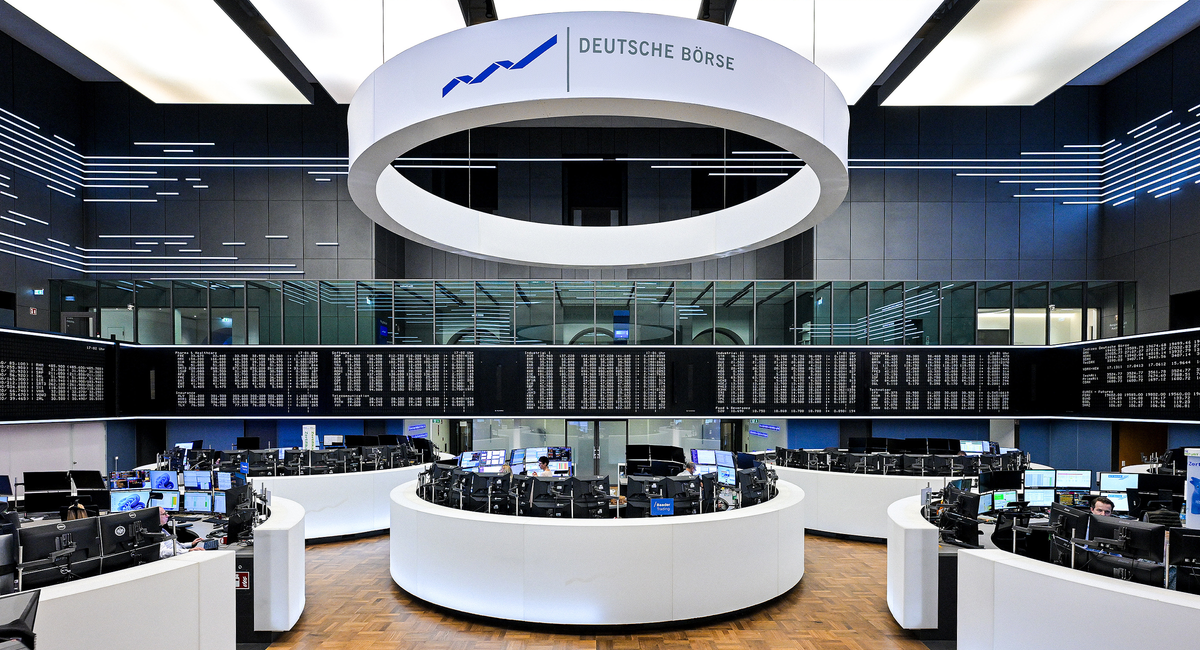 Handelsraum der Deutschen Börse mit kreisförmigem Display, modernen Arbeitsplätzen und digitalen Anzeigetafeln.